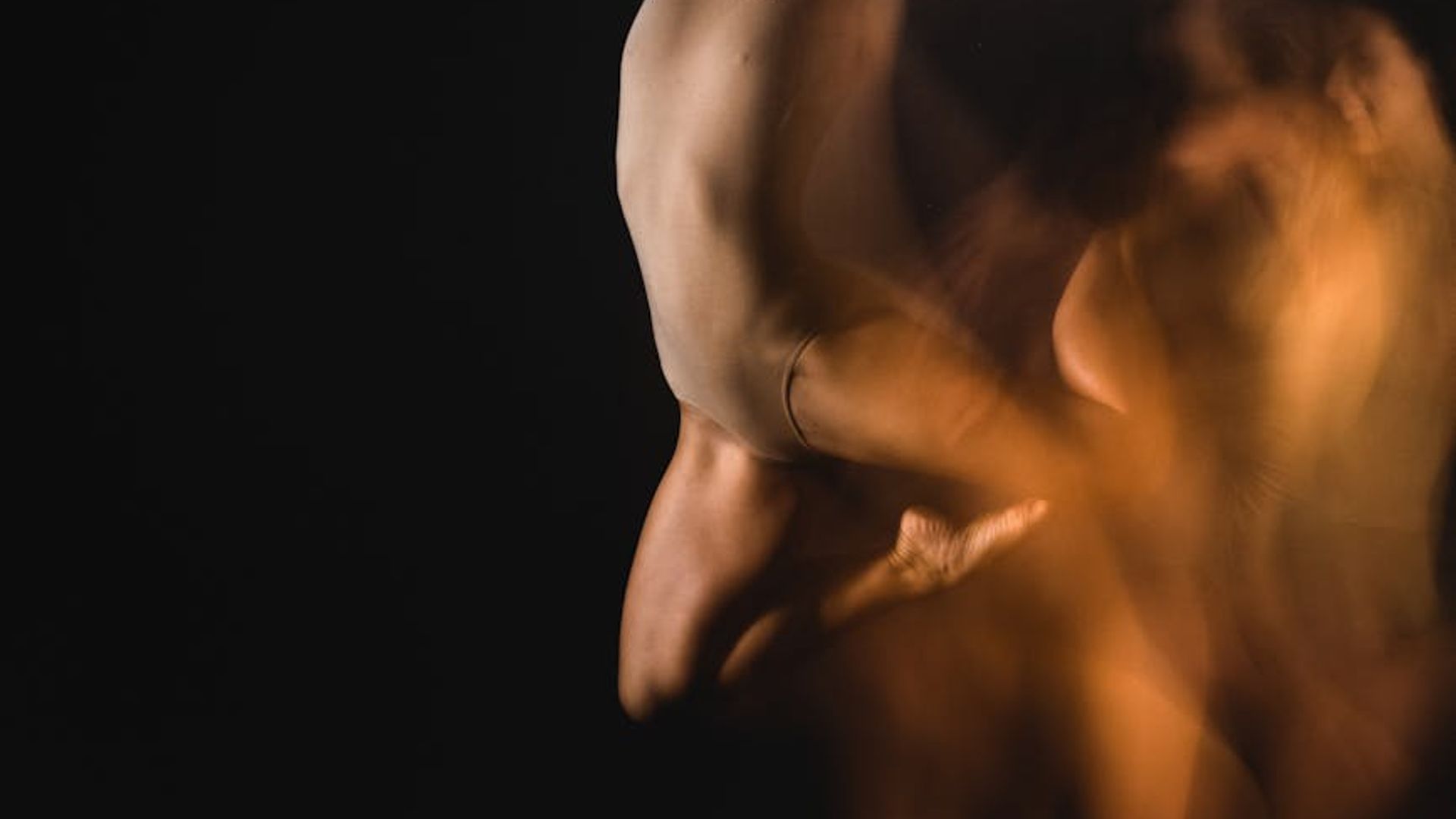 Active person moving in a dark studio with purple light